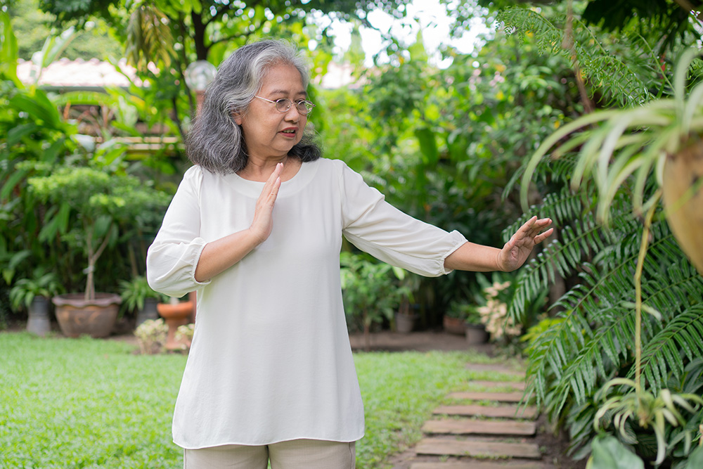 A woman practicing gentle movement outdoors